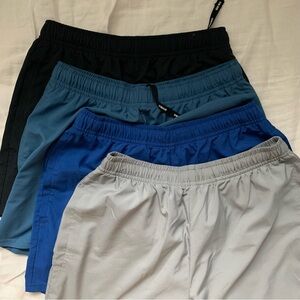 Gymshark Arrival 5” shorts in black, grey, utility blue, and vintage blue